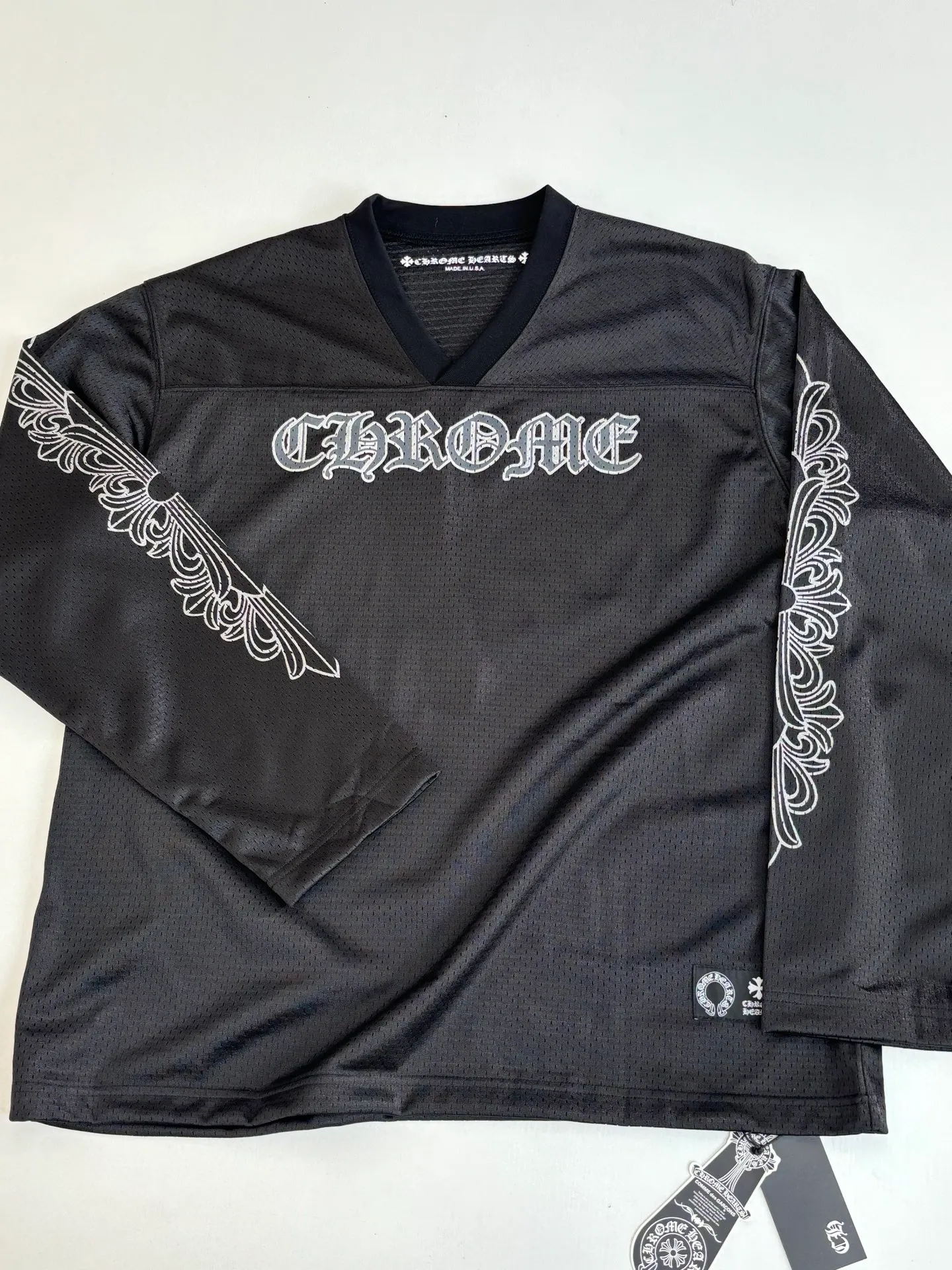 P340 Chrome Heart*/Chrome Heart Sanskrit mesh ice hockey suit long sleeves. The original version was purchased for 15,989 and developed. The fabric is made of custom weaving and dyeing technology. It is made of selected black mesh fabric, showing a unique sports style. The fabric has been specially treated to provide excellent breathability and comfort while maintaining a crisp and structured look. The double-layer design structure enhances the overall texture and makes the wearing experience more three-dimensional and full. The brand's iconic patterns are printed in many places, and high-precision printing technology is used to ensure that the patterns are clear and sharp. The silver printing has a glitter effect, showing charming luster changes under different lights. All printings undergo strict color difference control to ensure accurate color reproduction. The silver-plated pattern design on the sleeve arms is particularly eye-catching, showing the brand's consistent dark luxury style. In terms of details, the latest custom-woven labels are used, and the workmanship is exquisite. The overall shape is designed for both men and women, with both fashion and practicality. This T-shirt perfectly combines sports elements with high fashion craftsmanship, making it the brand's iconic street style item.  Size：S/M/L